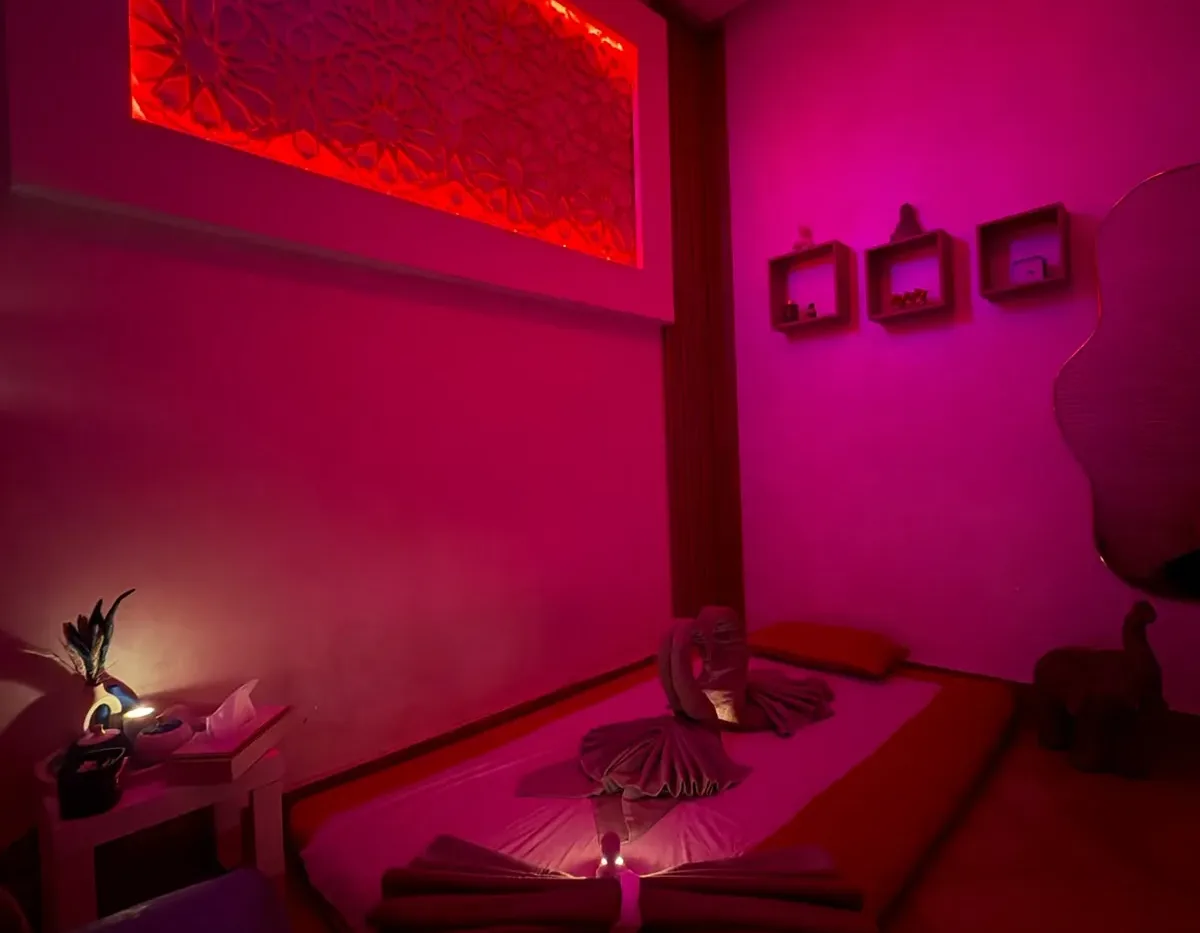 Cabine de massage au sol avec serviettes pliées et panneau sculpté rétroéclairé chez Yanis Prestige Spa