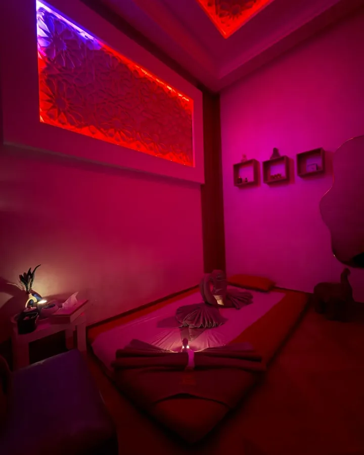 Cabine de massage au sol avec serviettes pliées et panneau sculpté rétroéclairé chez Yanis Prestige Spa