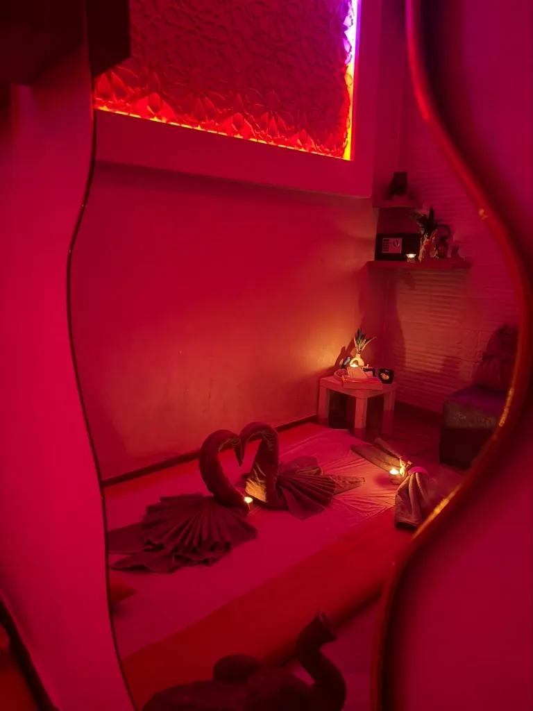 Reflet d'une cabine de massage de Yanis Prestige Spa dans un miroir ondulé, serviettes en forme de cygnes