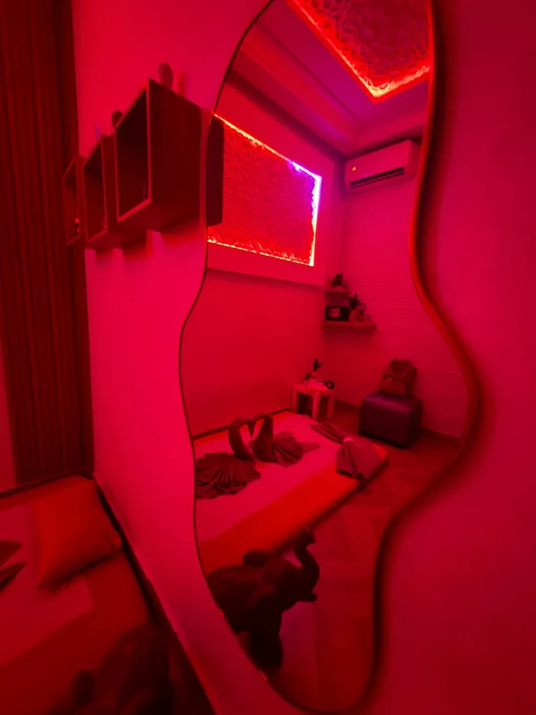 Miroir organique reflétant la cabine de massage et son panneau lumineux chez Yanis Prestige Spa