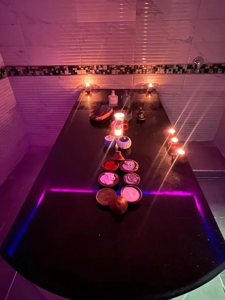 Bols de savon noir, rhassoul et gommages disposés sur la table du hammam de Yanis Prestige Spa