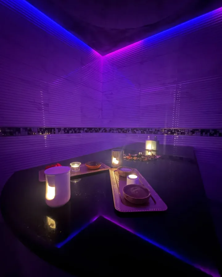 Table de gommage en marbre noir éclairée à la bougie dans le hammam de Yanis Prestige Spa