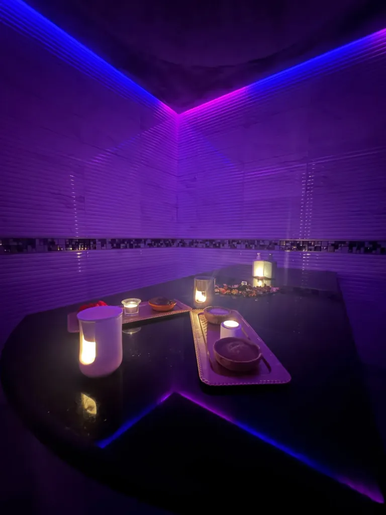 Table de gommage en marbre noir éclairée à la bougie dans le hammam de Yanis Prestige Spa